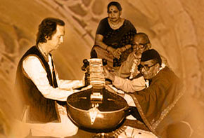 Mushtaq Ali Khan places the surbahar into my hands, the traditional method of introducing the student to the instrument before actual training is begun. D.T. Joshi and Ustadji's wife witnesses the occasion. Mushtaq Ali Khan places the surbahar into my hands, the traditional method of introducing the student to the instrument before actual training is begun. D.T. Joshi and Ustadji's wife witnesses the occasion.